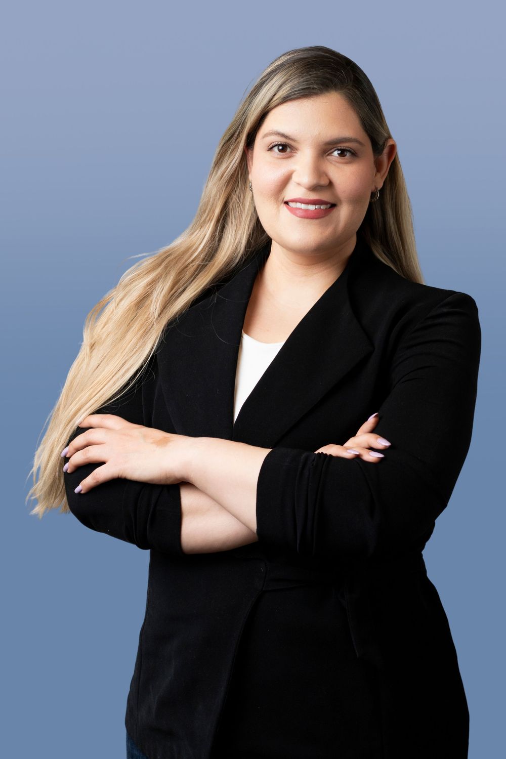 Professional headshot series against blue background showing different poses in a black blazer and white top.