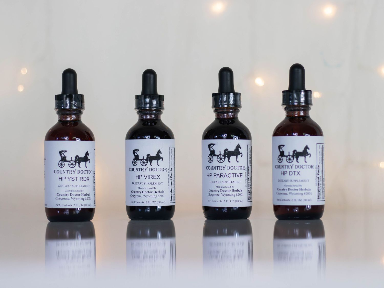 Four identical brown glass dropper bottles with matching labels displayed in a row.