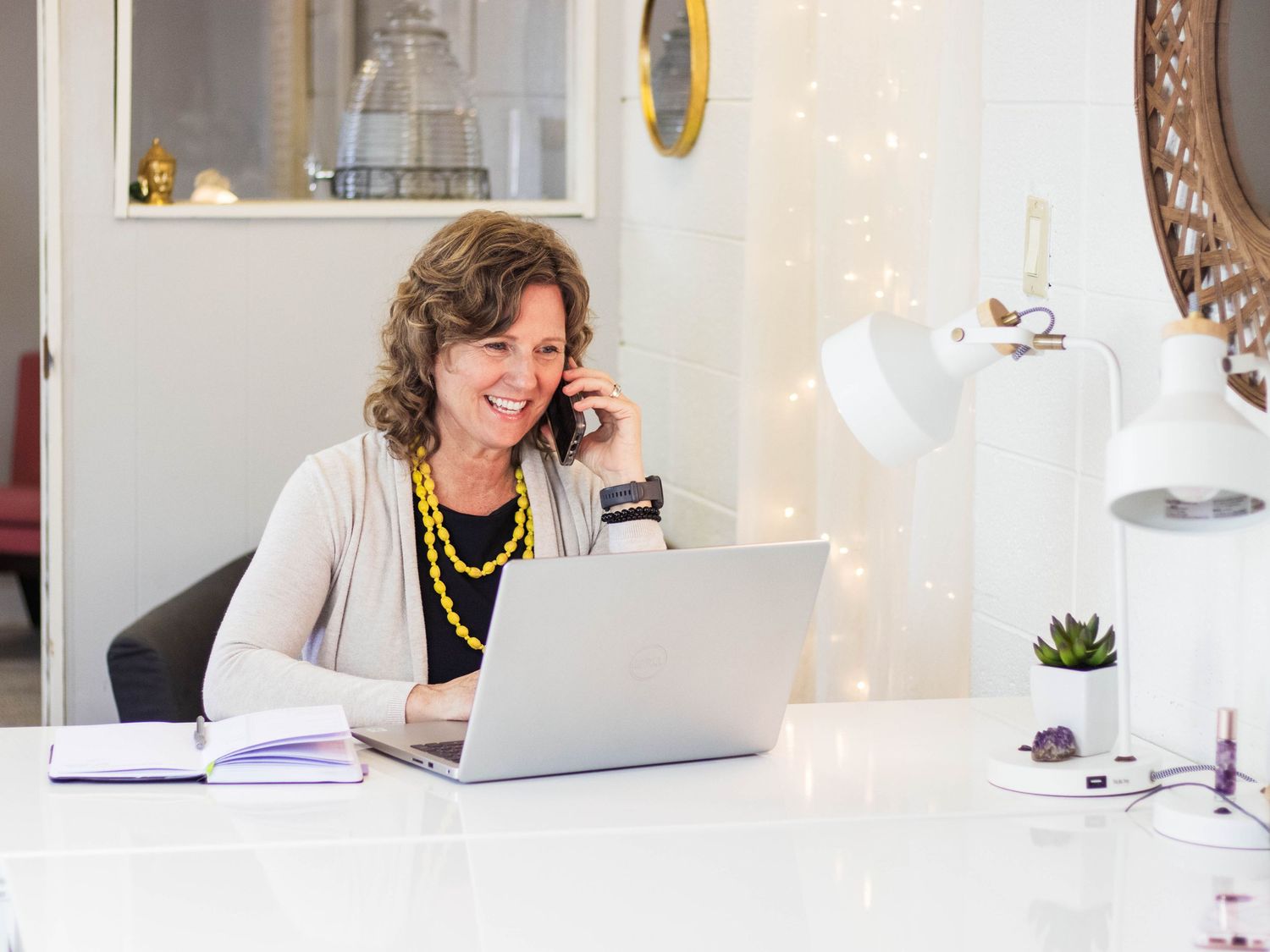 Professional working on laptop in bright office space with modern decor.