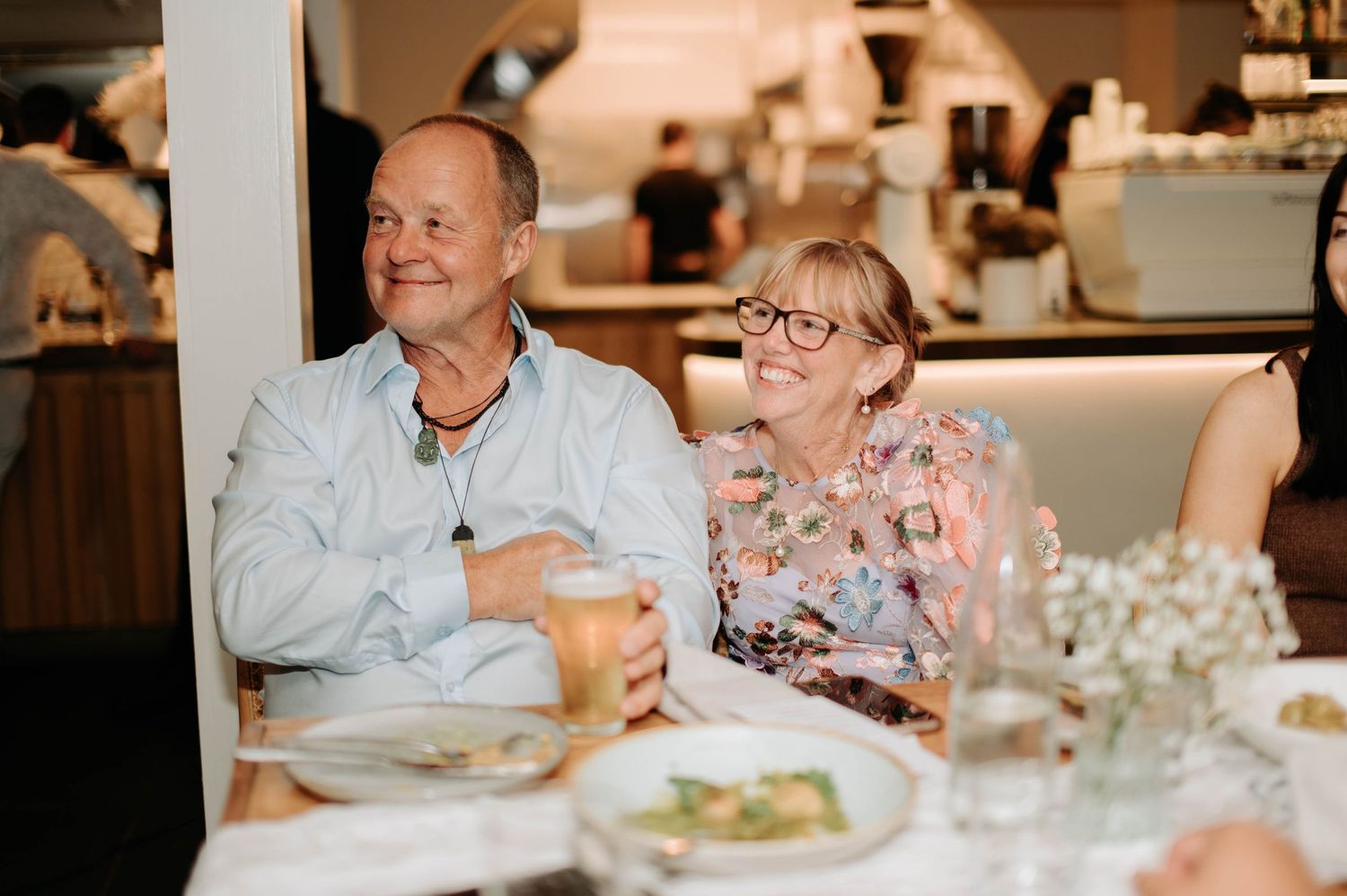 Guests enjoying a moment during a wedding reception dinner at an indoor venue.