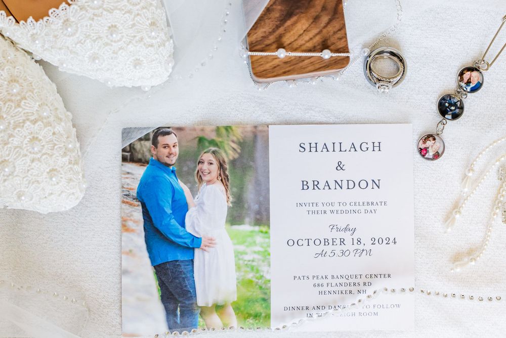 Wedding invitation with couple's photo displayed alongside rings and decorative elements.