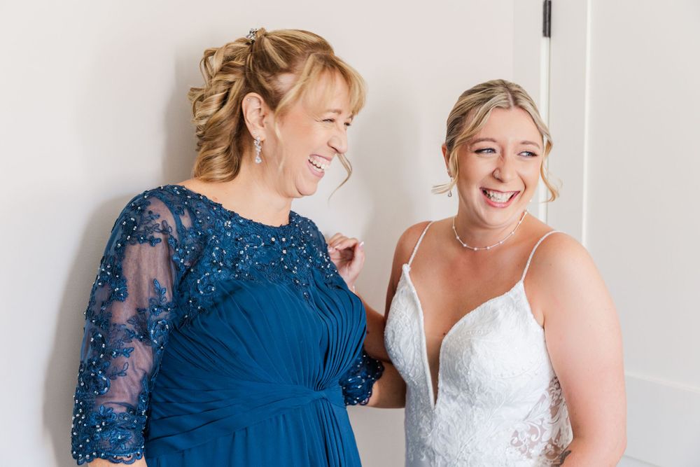 Joyful pre-wedding moment showing two people sharing a laugh while getting ready.