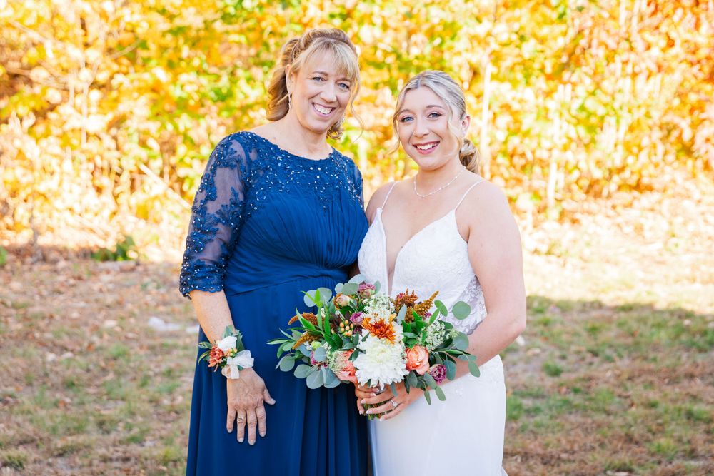 Elegant outdoor wedding portrait with autumn colors in the background.