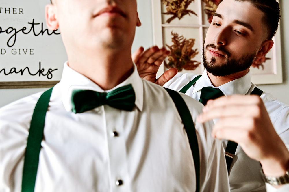 Groomsmen in white shirts and green bow ties getting ready before ceremony.