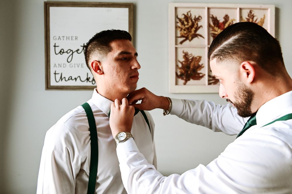 Wedding preparation scene showing formal attire adjustments.