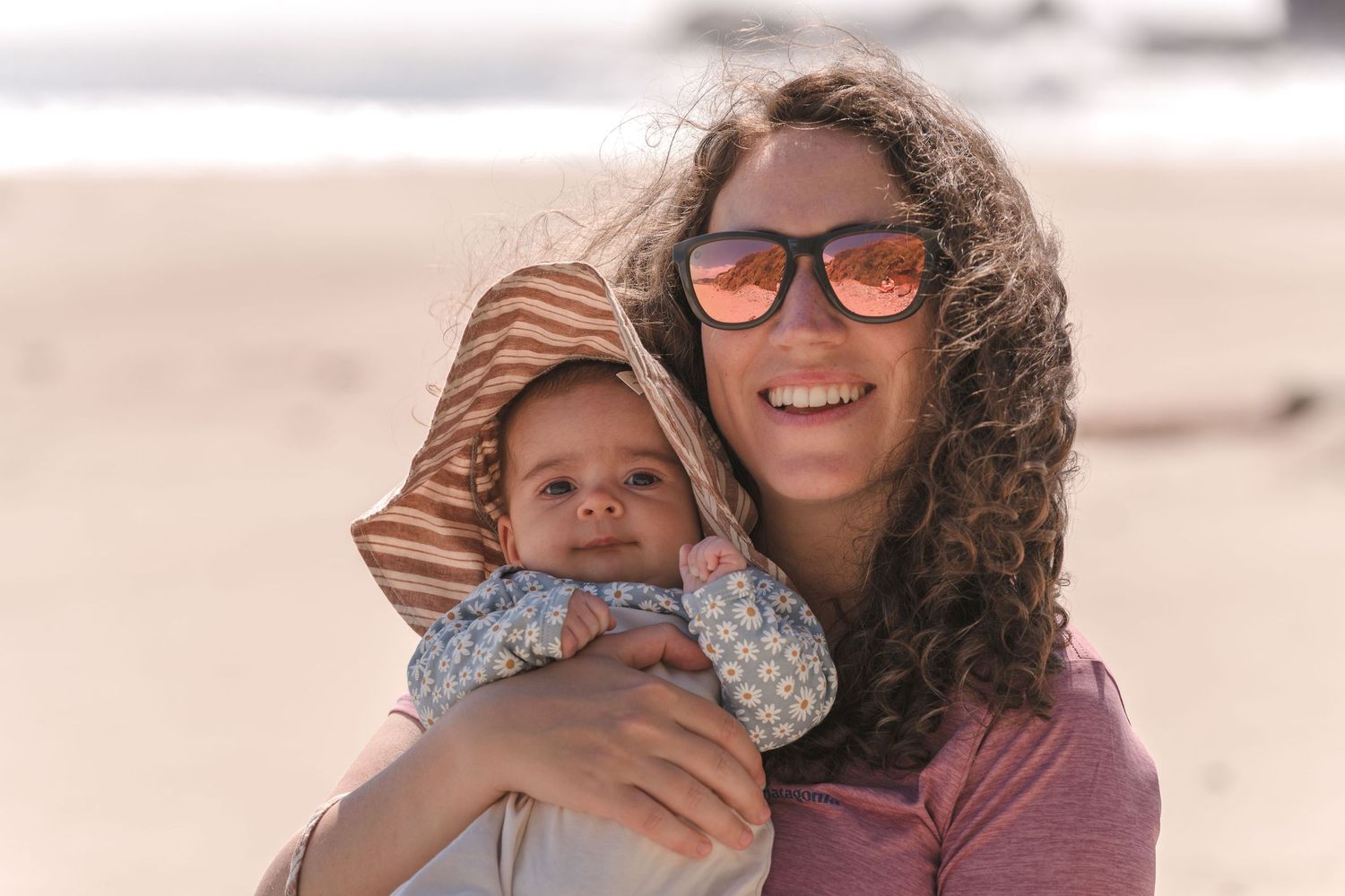 Happy beach portrait showing joyful embrace against coastal backdrop. Located near Santa Cruz, CA.