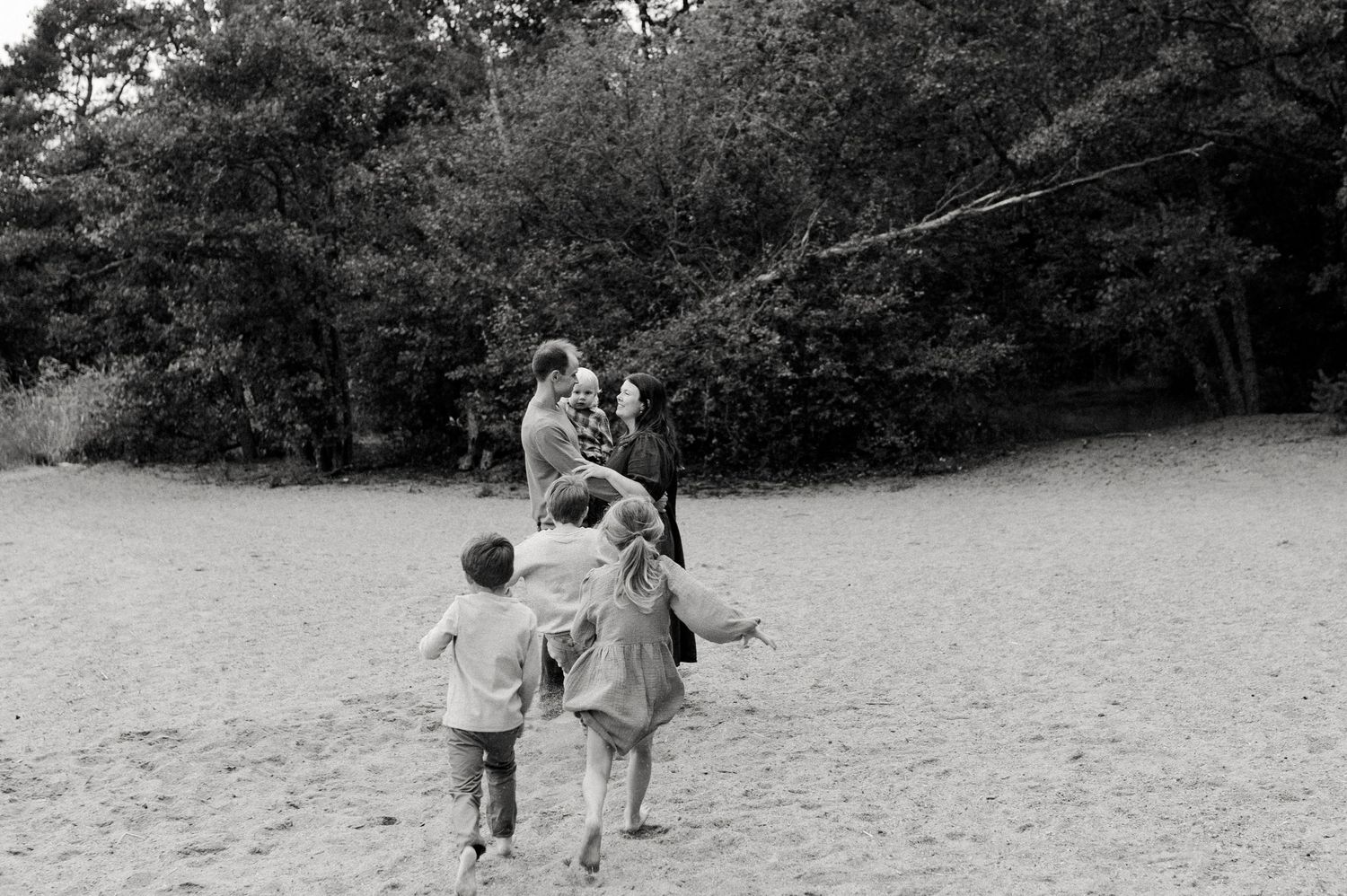 A casual family moment captured in black and white photography outdoors.