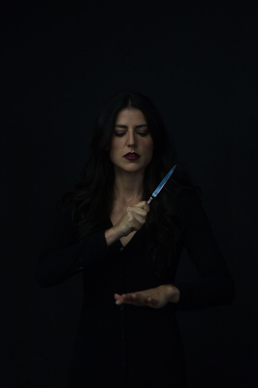 No Name Collective, Macbeth Theatre production promo photography. Dark, low lit moody image of Annaliese Kirby holding dagger.