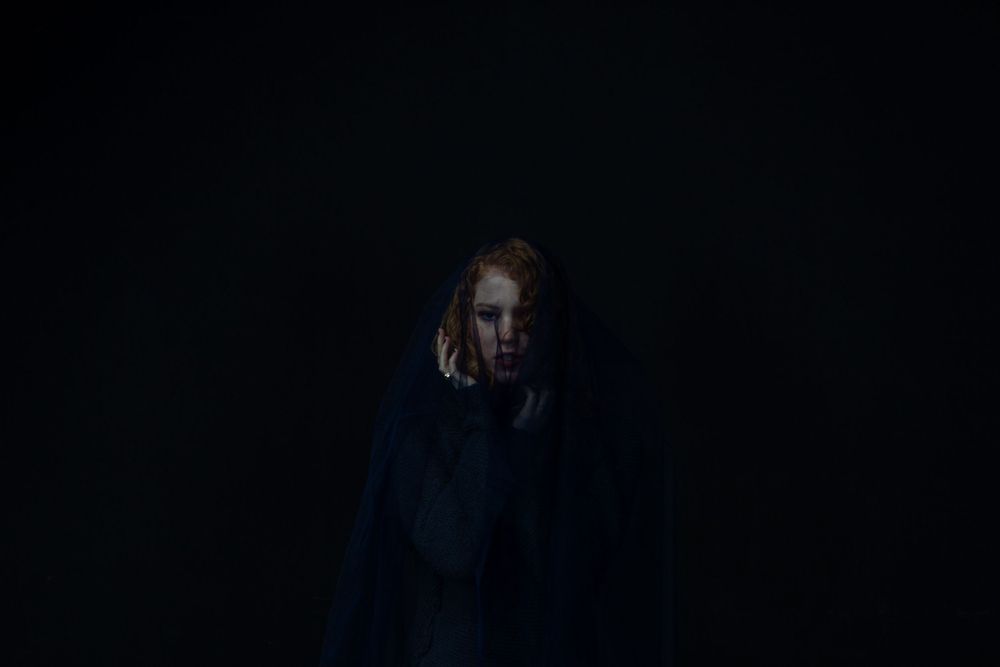 No Name Collective, Macbeth Theatre production promo photography. Dark, low lit moody image of Maggie Hood with fabric over her head.