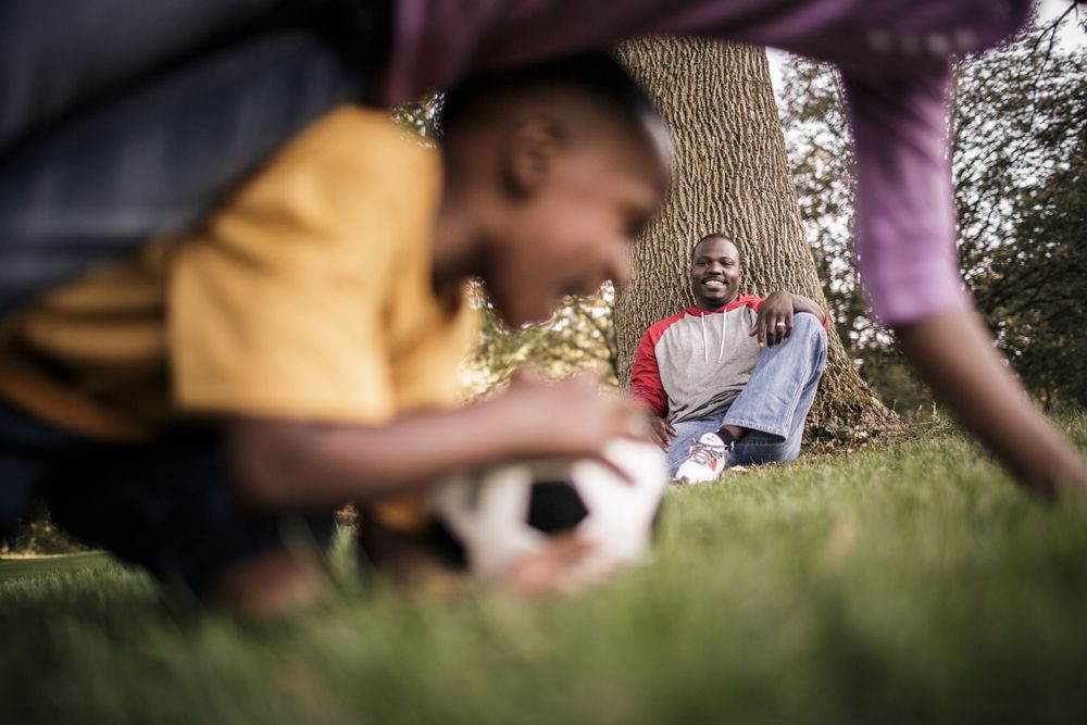 Soccer being played in a grassy field during a casual game.