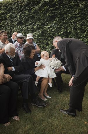 Wedding guests participating in a playful outdoor group activity on the lawn.