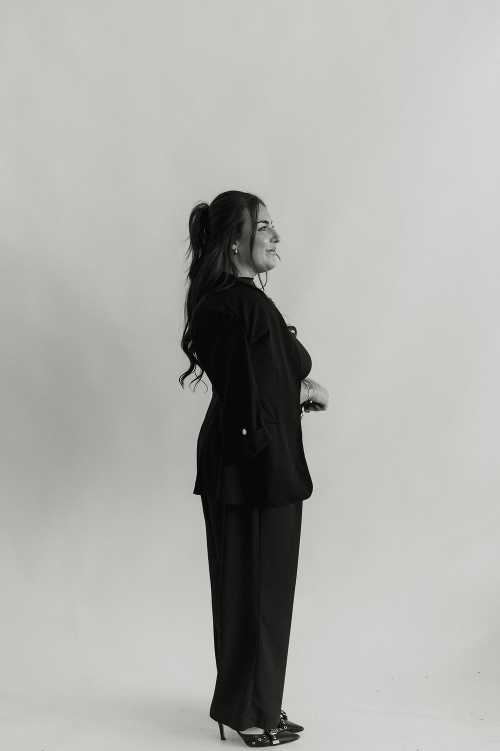 Black and white artistic photo sequence showing a figure in dark clothing spinning in a circle against a light background.