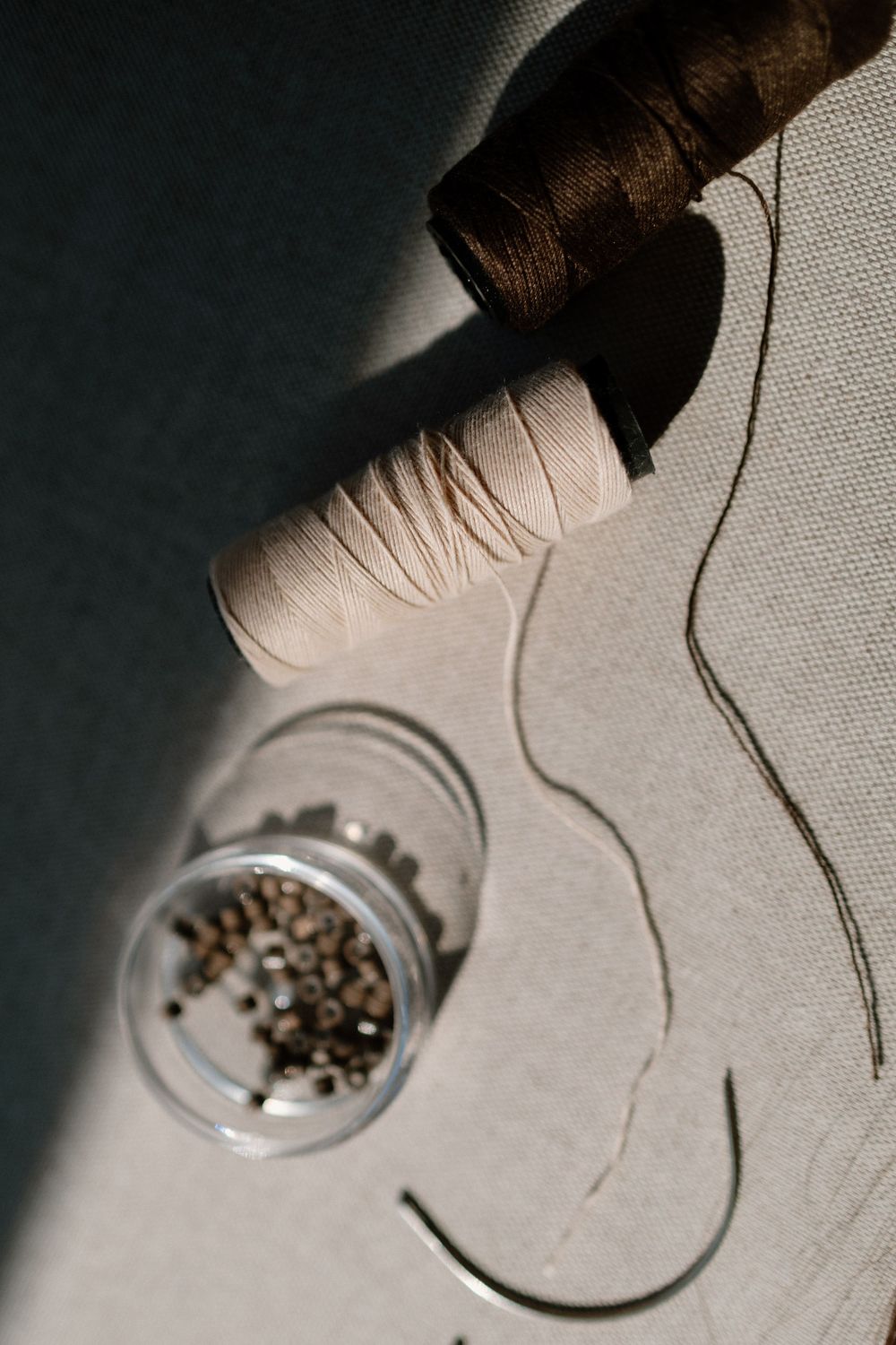 Close-up sequence of small metal parts being placed into a circular container on a light gray surface.