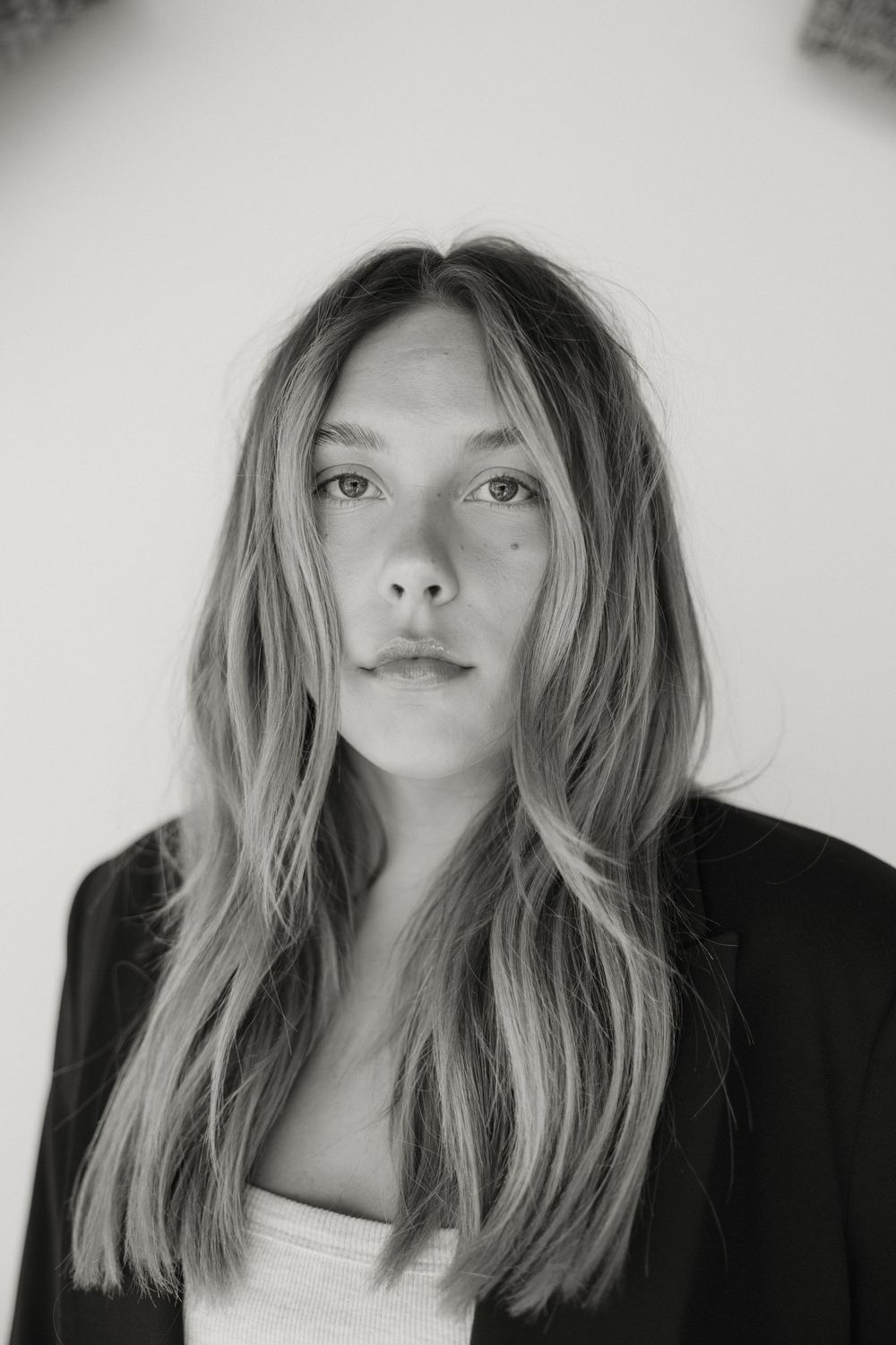 Black and white portrait series showing playful expressions with tousled blonde hair and natural lighting.