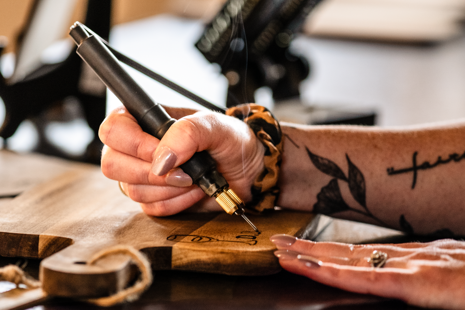 Close-up view of hands writing with pen and paper on a rustic wooden desk with coffee cup and natural lighting.