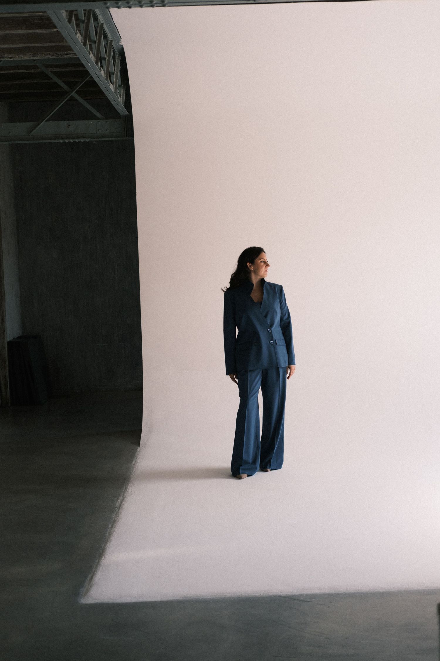 Fashion designer wearing blue suit in her Milan studio branding portrait photography session.