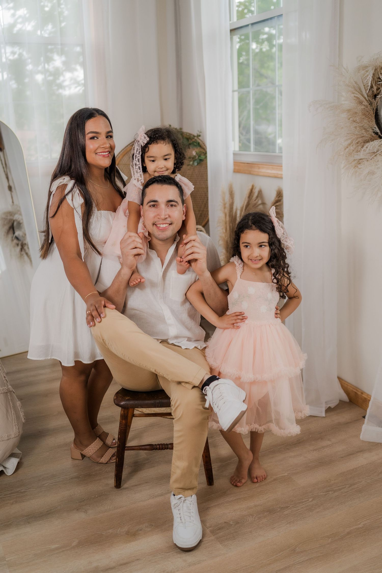 A series of candid family photos showing joyful dancing and twirling moments in a bright indoor setting with white curtains.