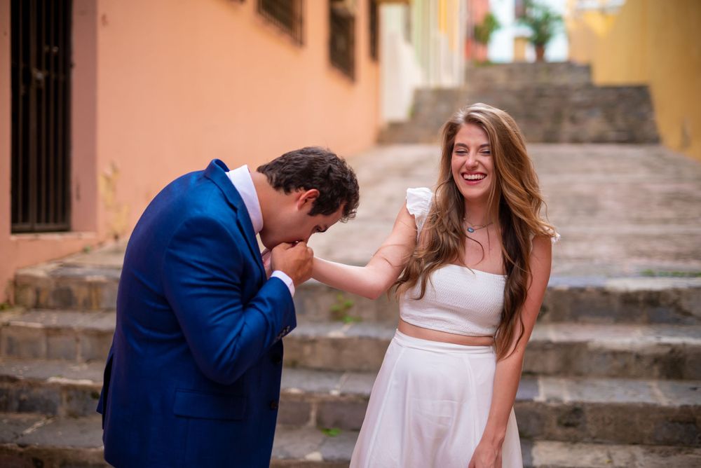 Joyful moment on terracotta stairs with white dress and blue blazer.