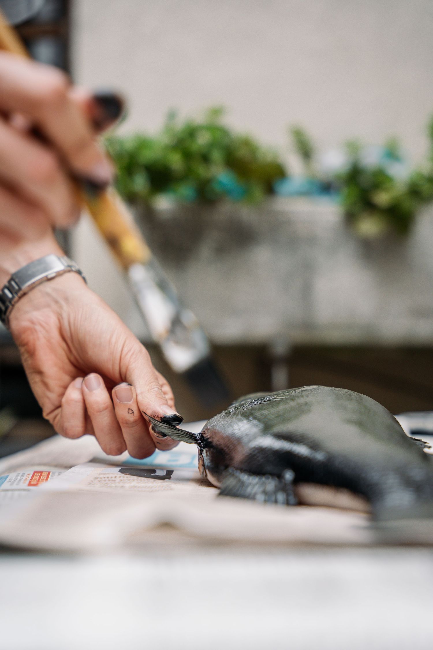 Close-up of hands preparing fresh fish on white cutting surface.