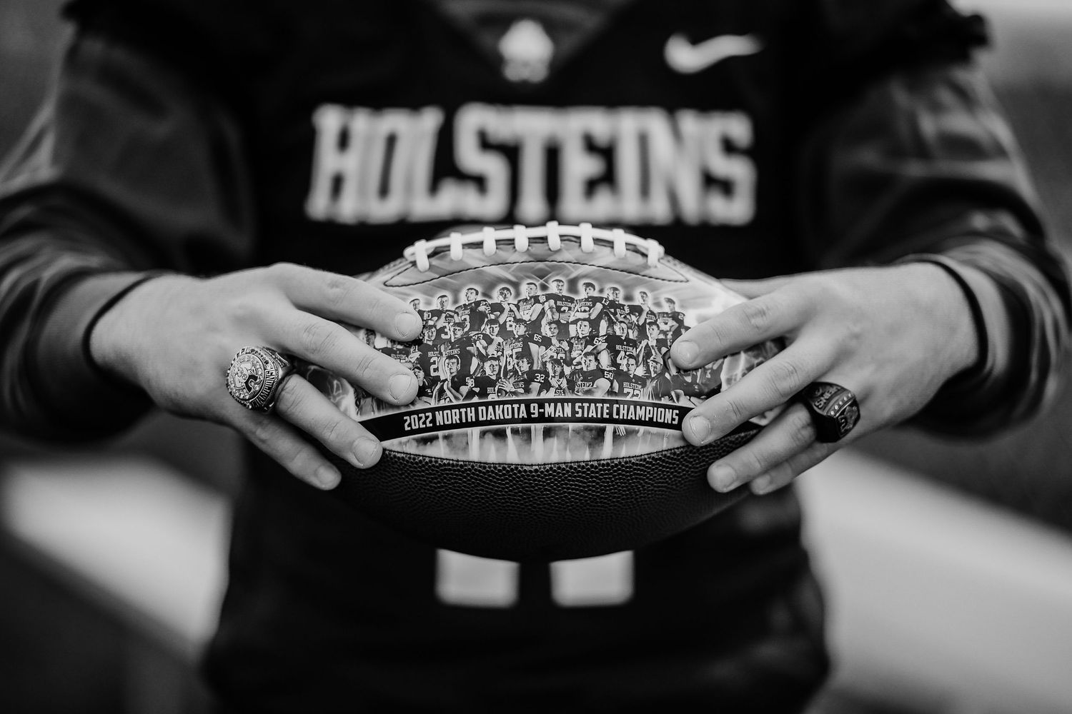 A series of black and white photographs showing hands holding championship rings in various poses.