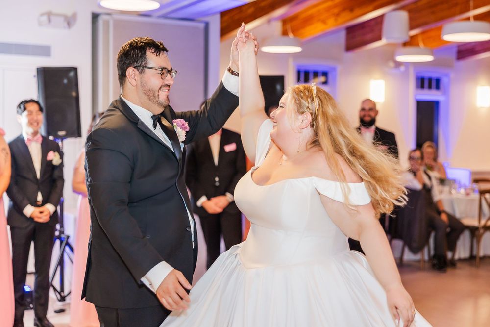 A celebratory dance moment at a wedding reception with the couple sharing an energetic dance in a decorated venue.