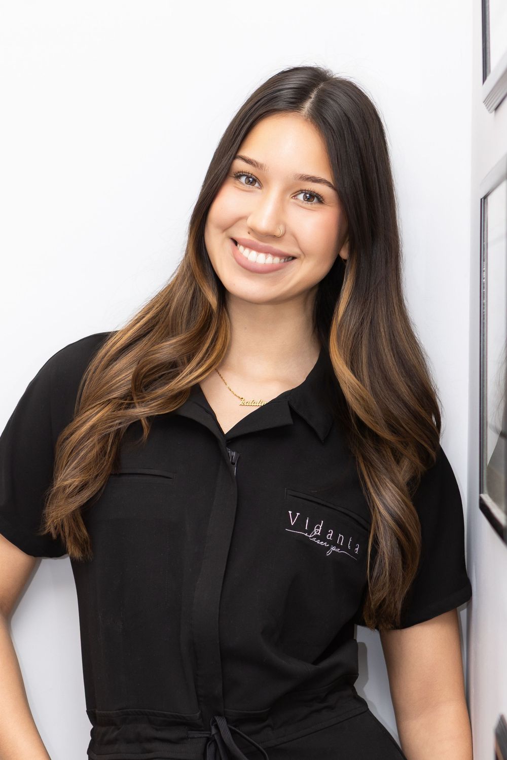 Professional woman in black polo shirt smiling against white background in multiple poses.