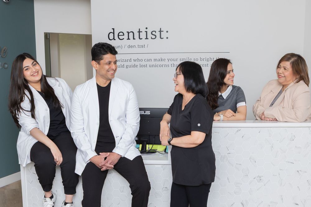 Medical professionals in white coats and business attire interact in a modern healthcare office setting.