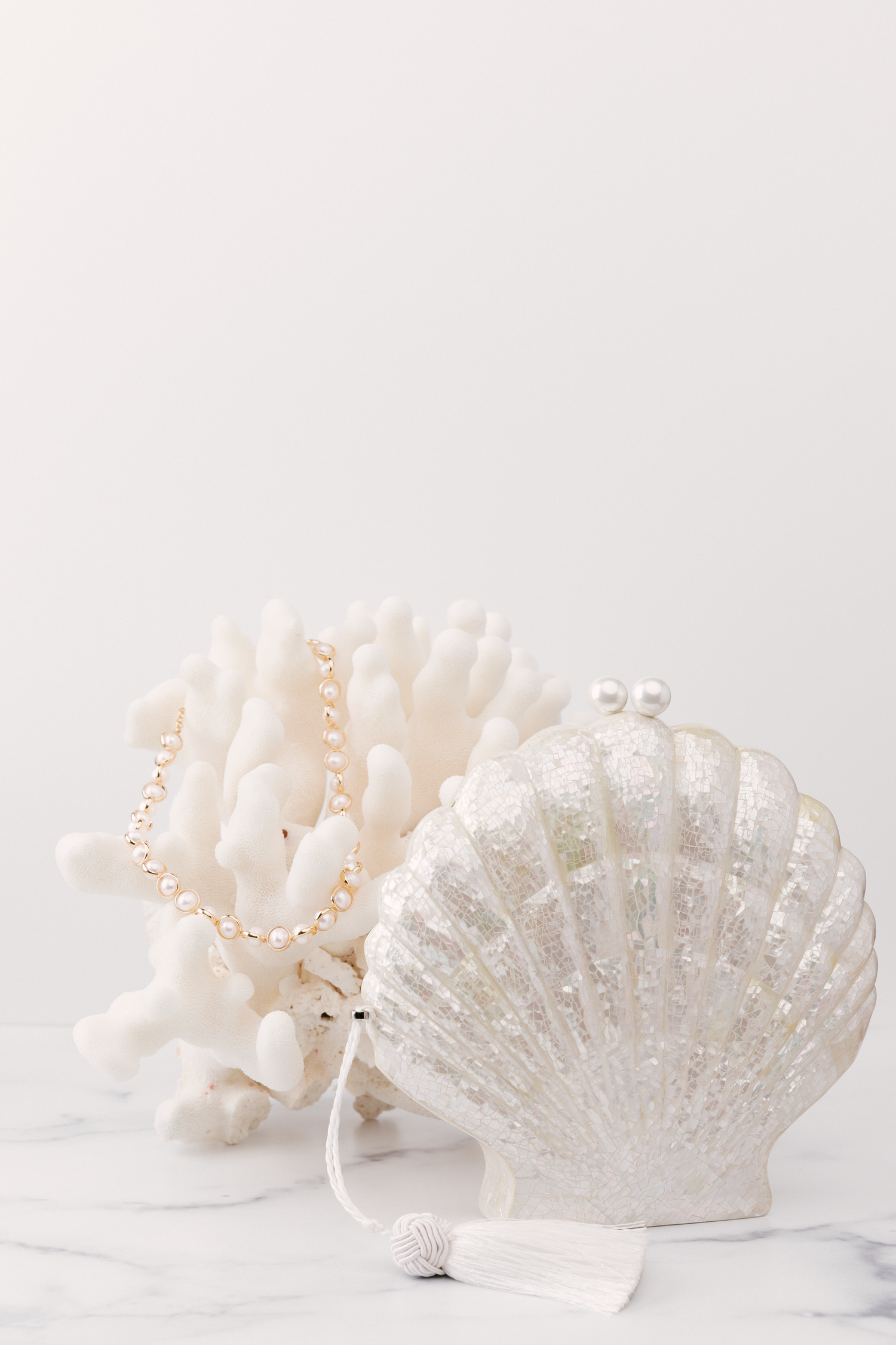 Decorative white ceramic peacock figurines with pearl accents arranged in a row against a white background.