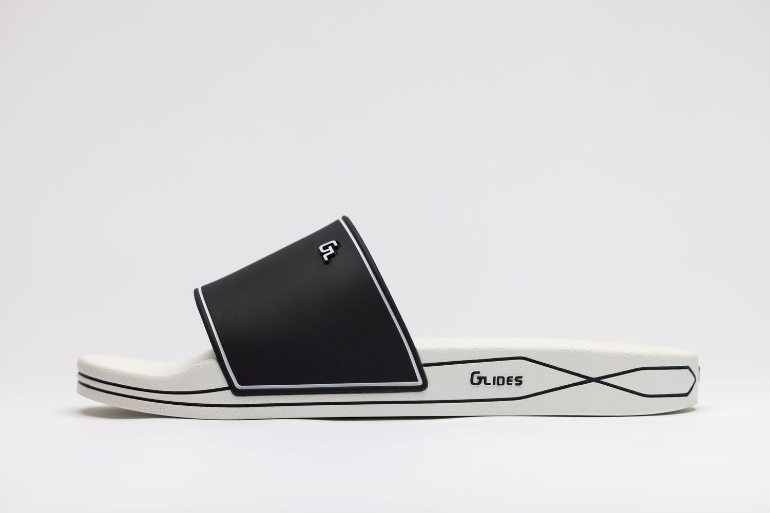 Side view of a minimalist black and white slide sandal with contrasting design elements and sleek profile.