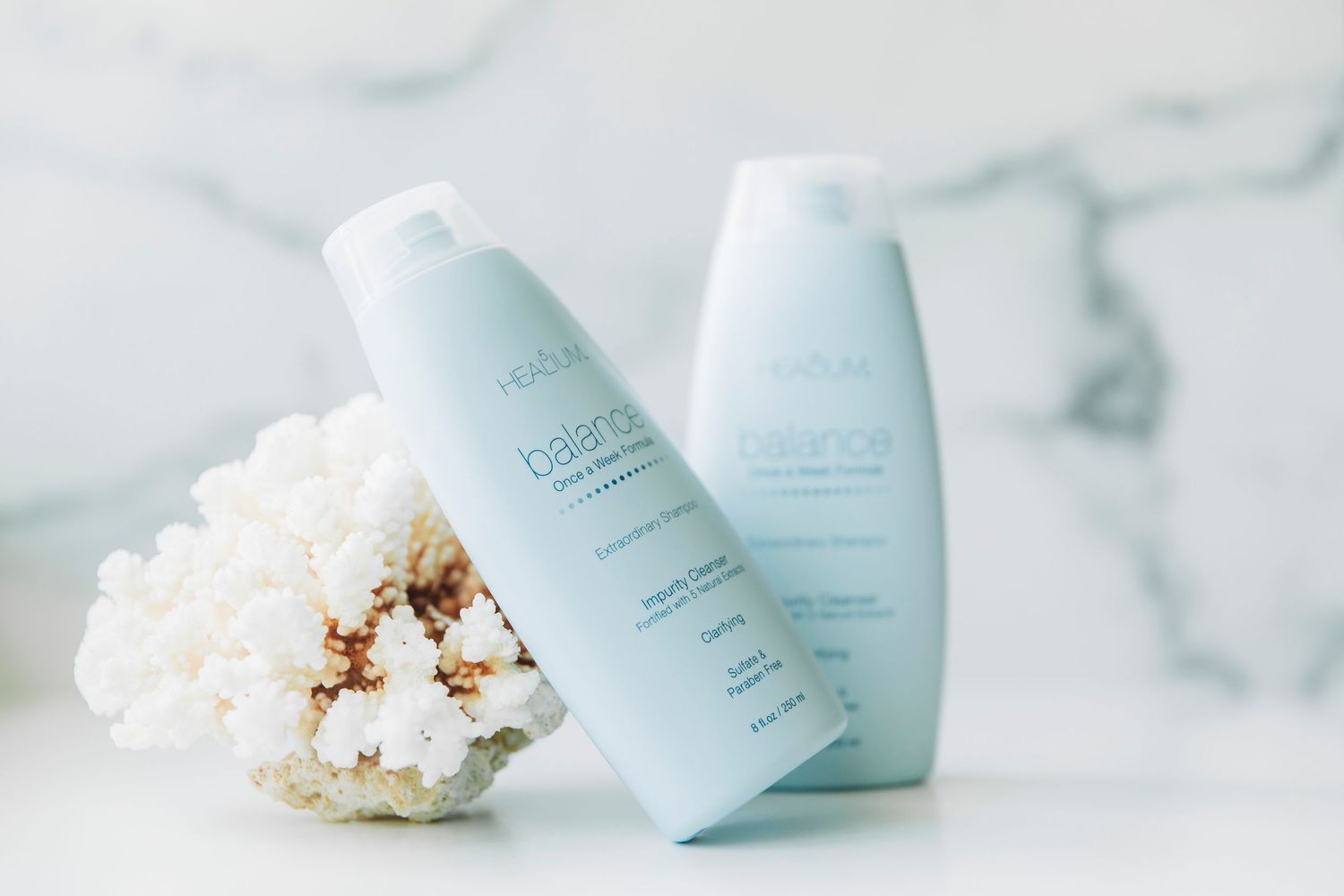 White beauty product containers arranged with popcorn on a light marble surface in a minimalist composition.