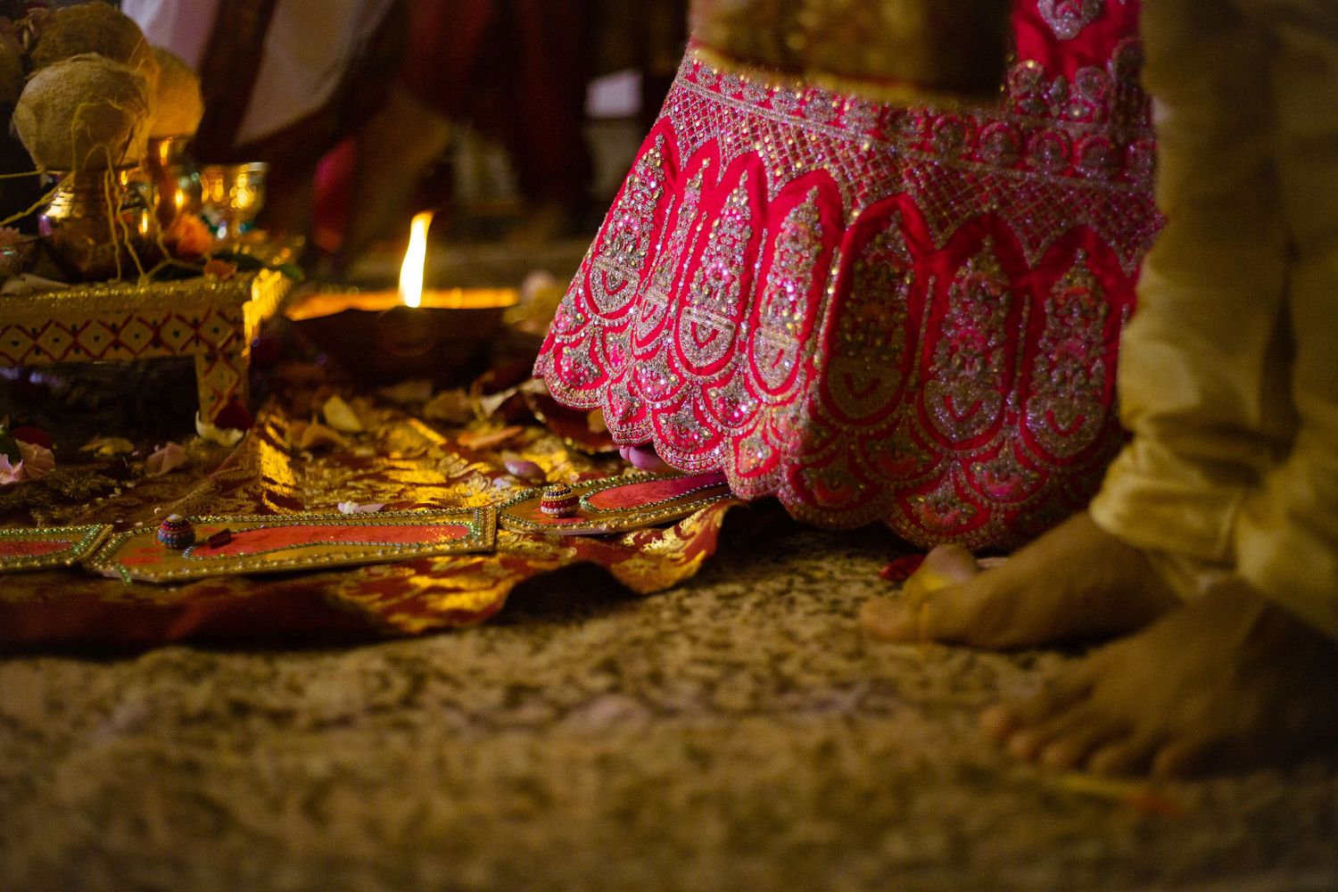 Detailed view of traditional Indian wedding attire with rich red embroidery and embellishments.