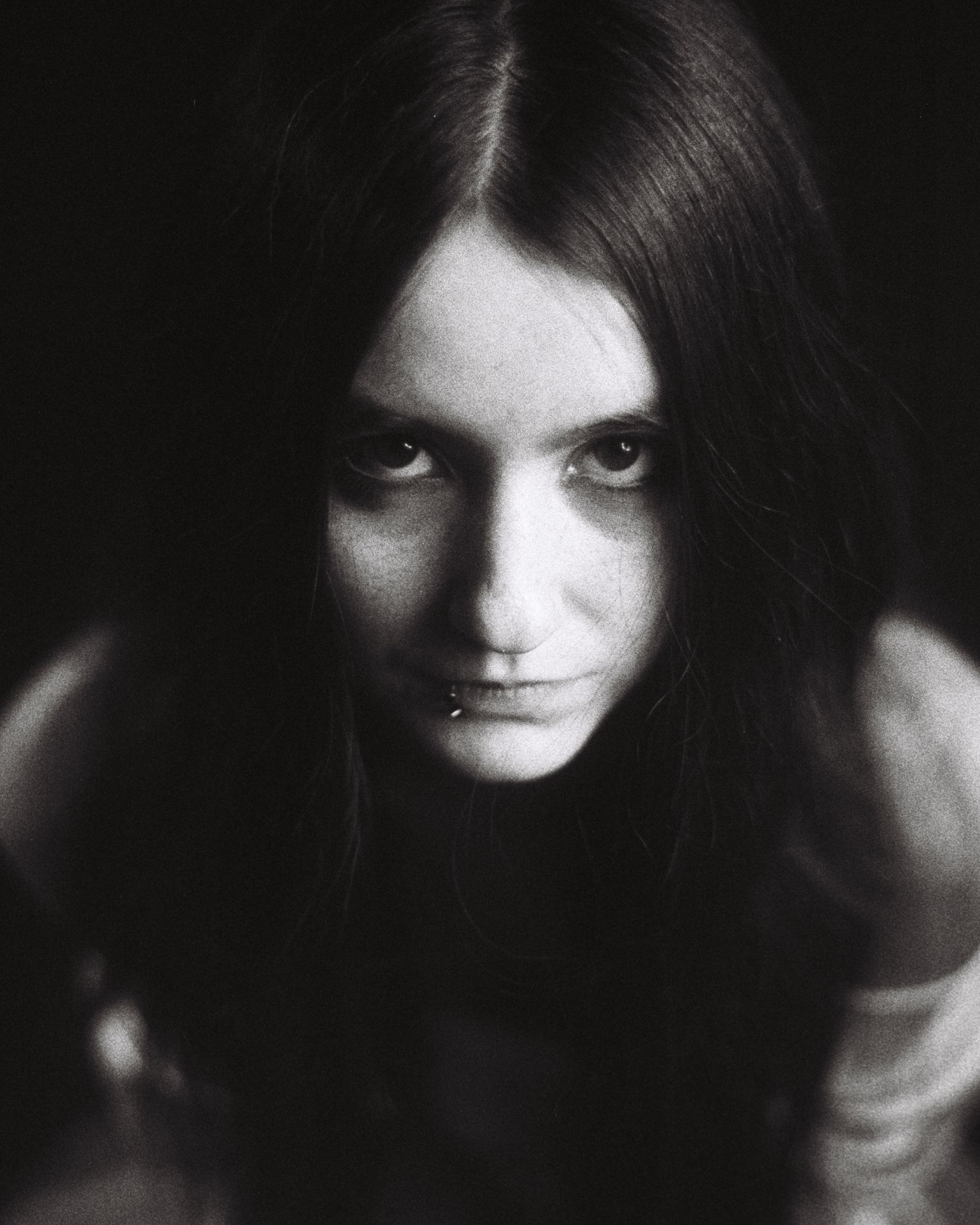 Someone in a white dress looks up at the camera with great intensity.