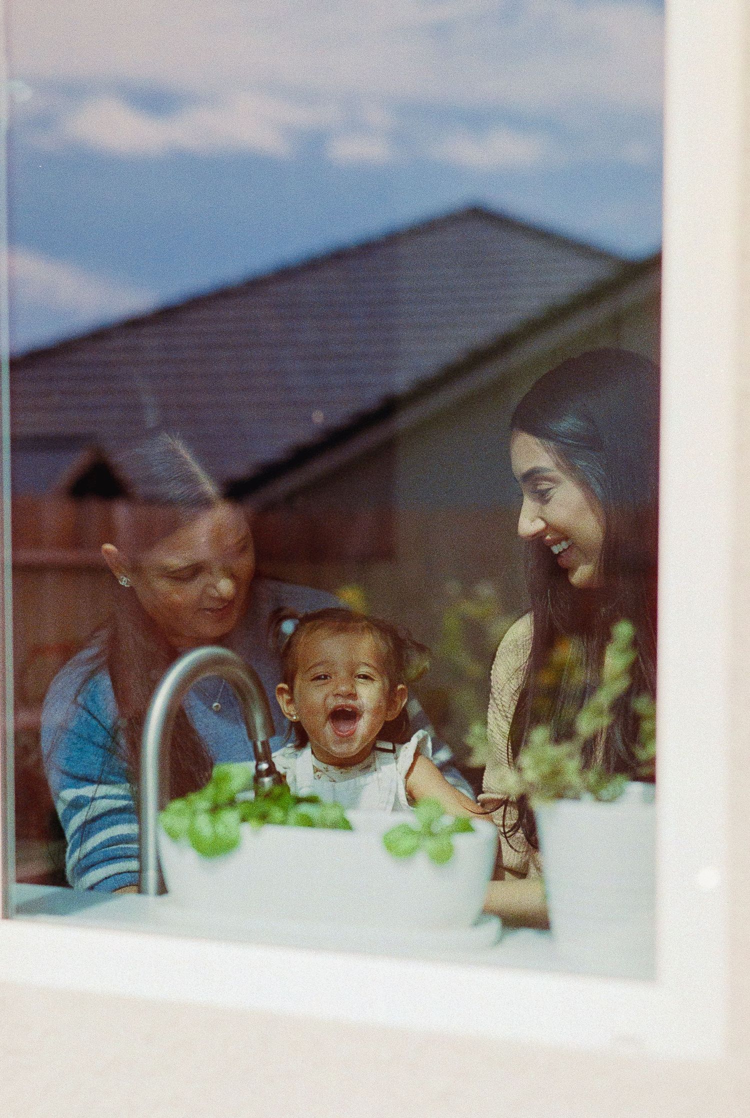A series of candid expressions viewed through a window reflection showing joyful reactions and laughter.