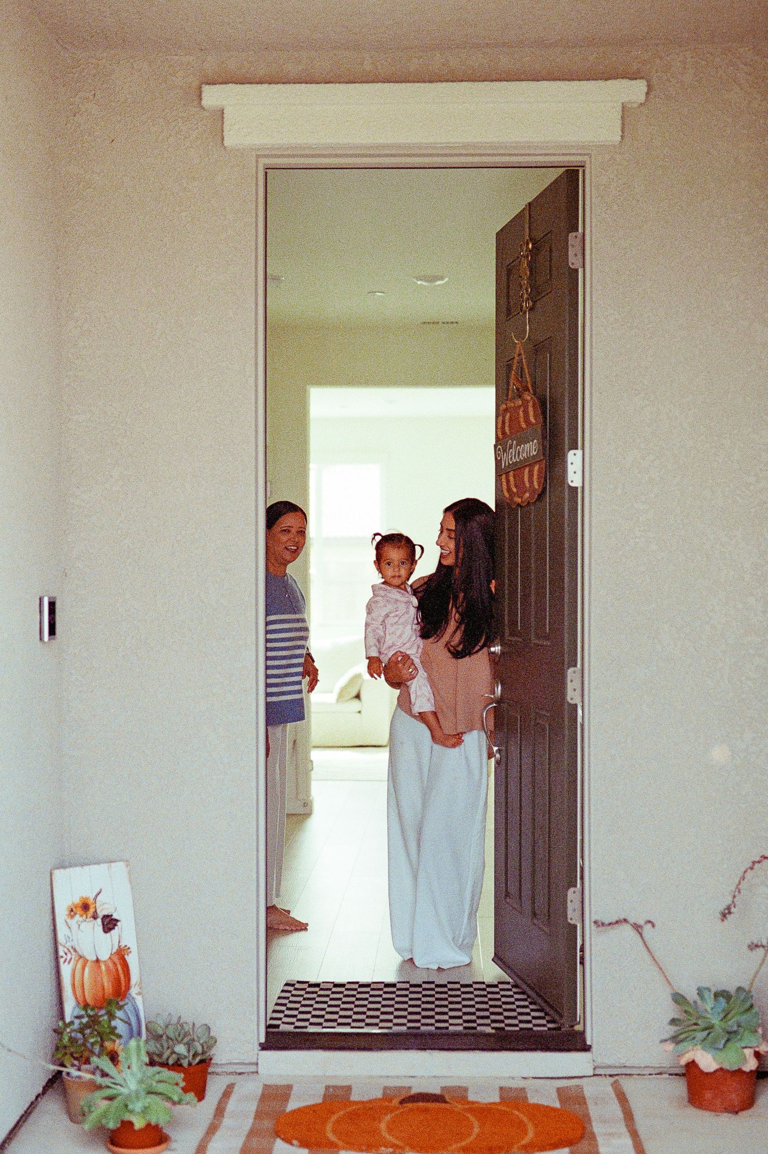A sequence of four doorway photos showing people entering and exiting through brown doors in a white hallway.