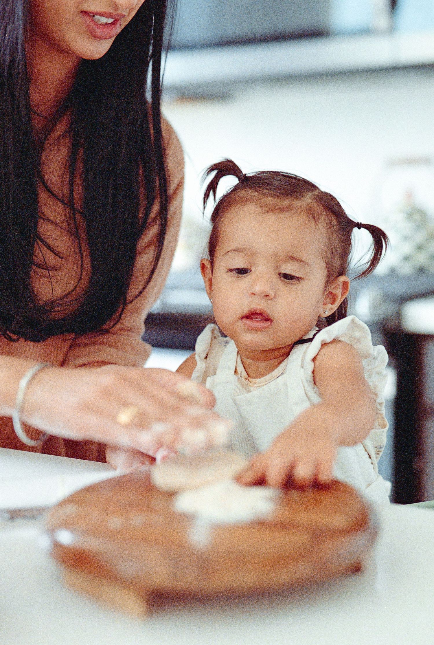 A sequence of photos showing a small child reaching for and eating food from a plate at a table.