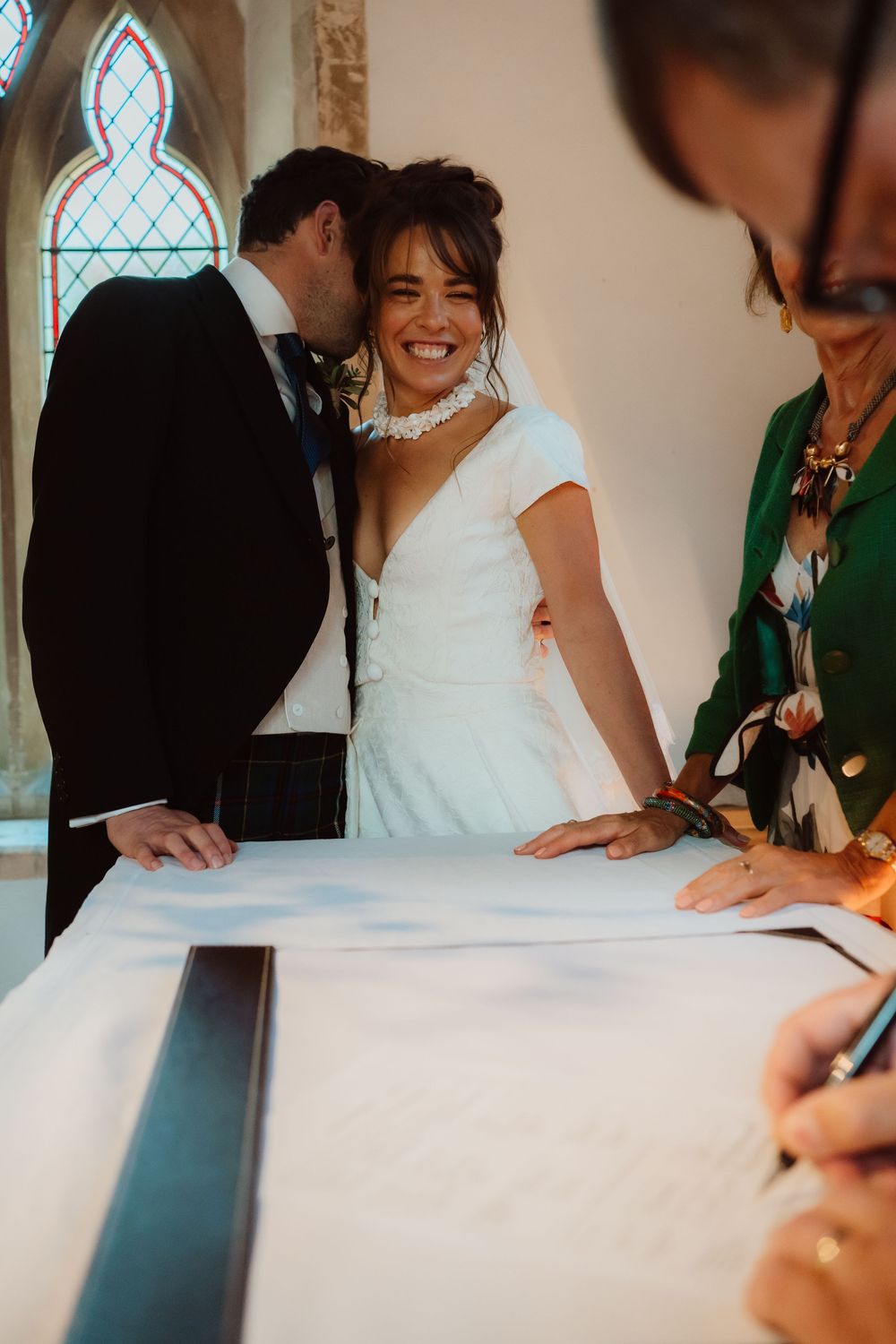 A series of photos showing wedding guests signing the marriage certificate at a ceremony.