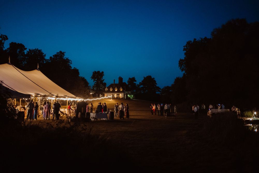 A series of outdoor evening wedding reception photos showing illuminated tents and string lights creating a romantic atmosphere.