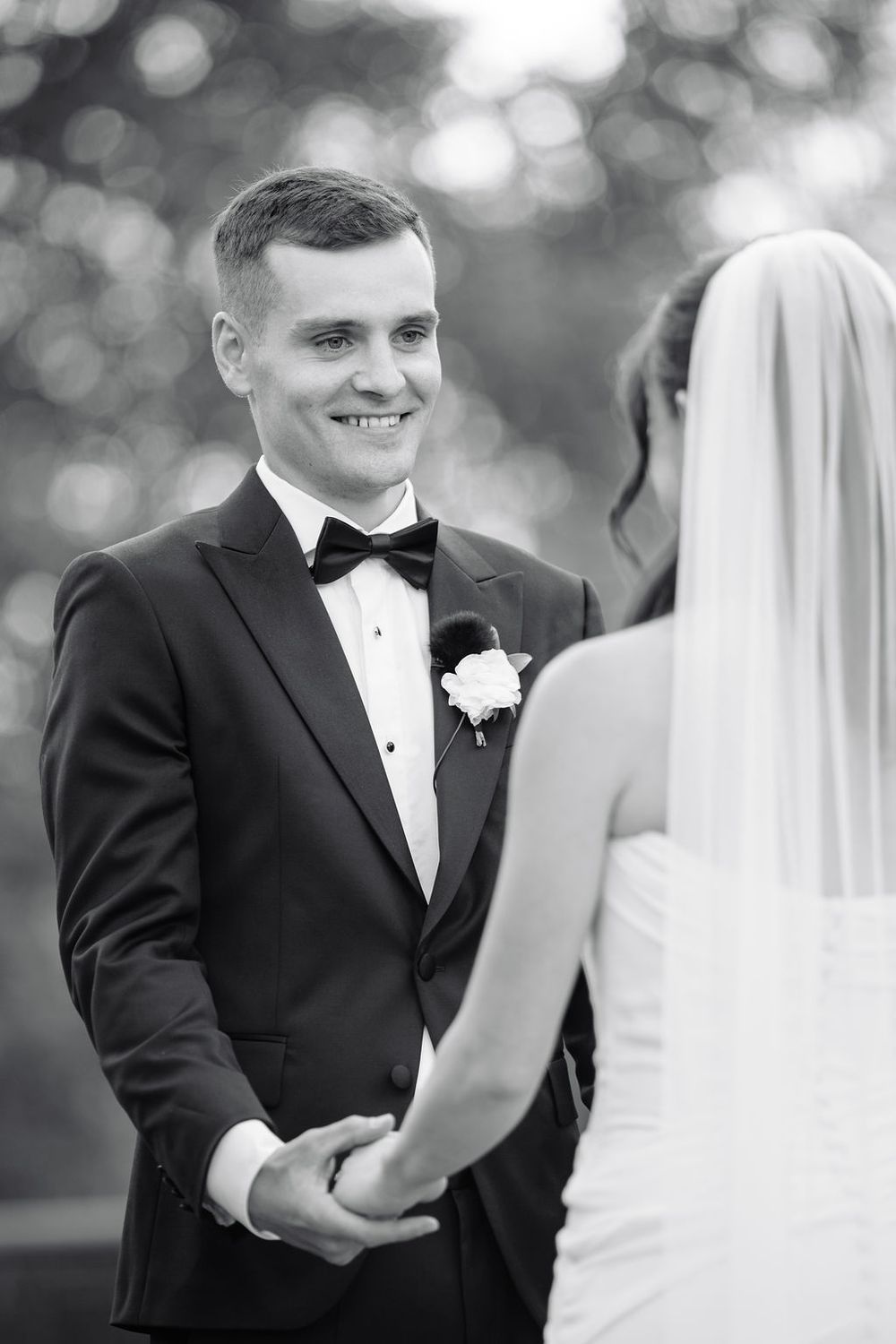 Black and white wedding portrait shows couple sharing an intimate moment during their ceremony.
