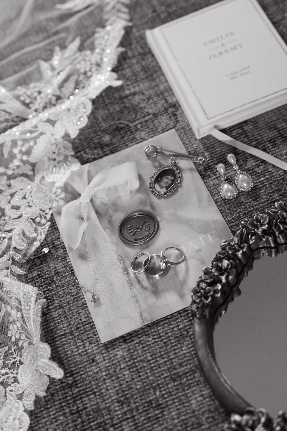 Wedding invitation and wax seal details arranged on textured burlap with delicate lace accents.