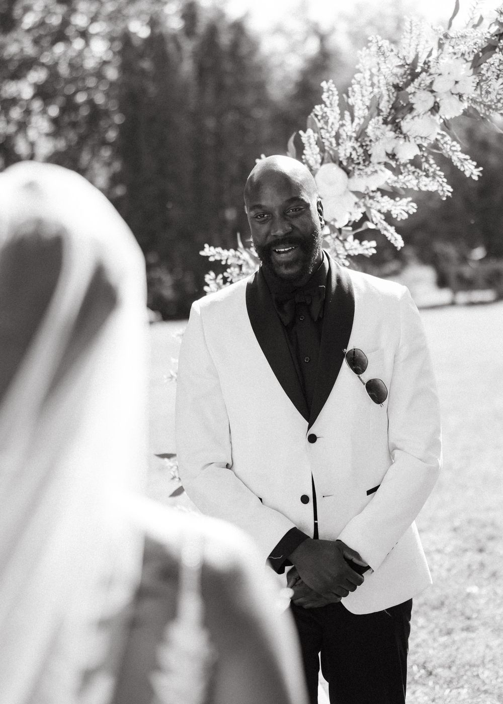 A black and white photo sequence shows a joyful moment between people in formal attire outdoors.