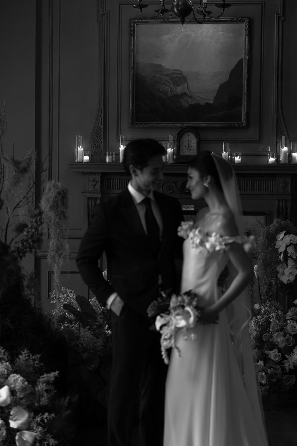 A romantic candlelit wedding scene with couples dancing in an elegant ballroom decorated with floral arrangements.