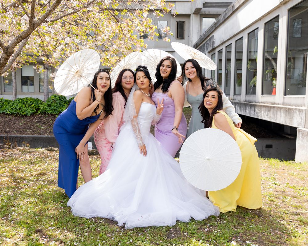 Wedding party in colorful pastel dresses and formal attire pose together on outdoor steps during autumn.