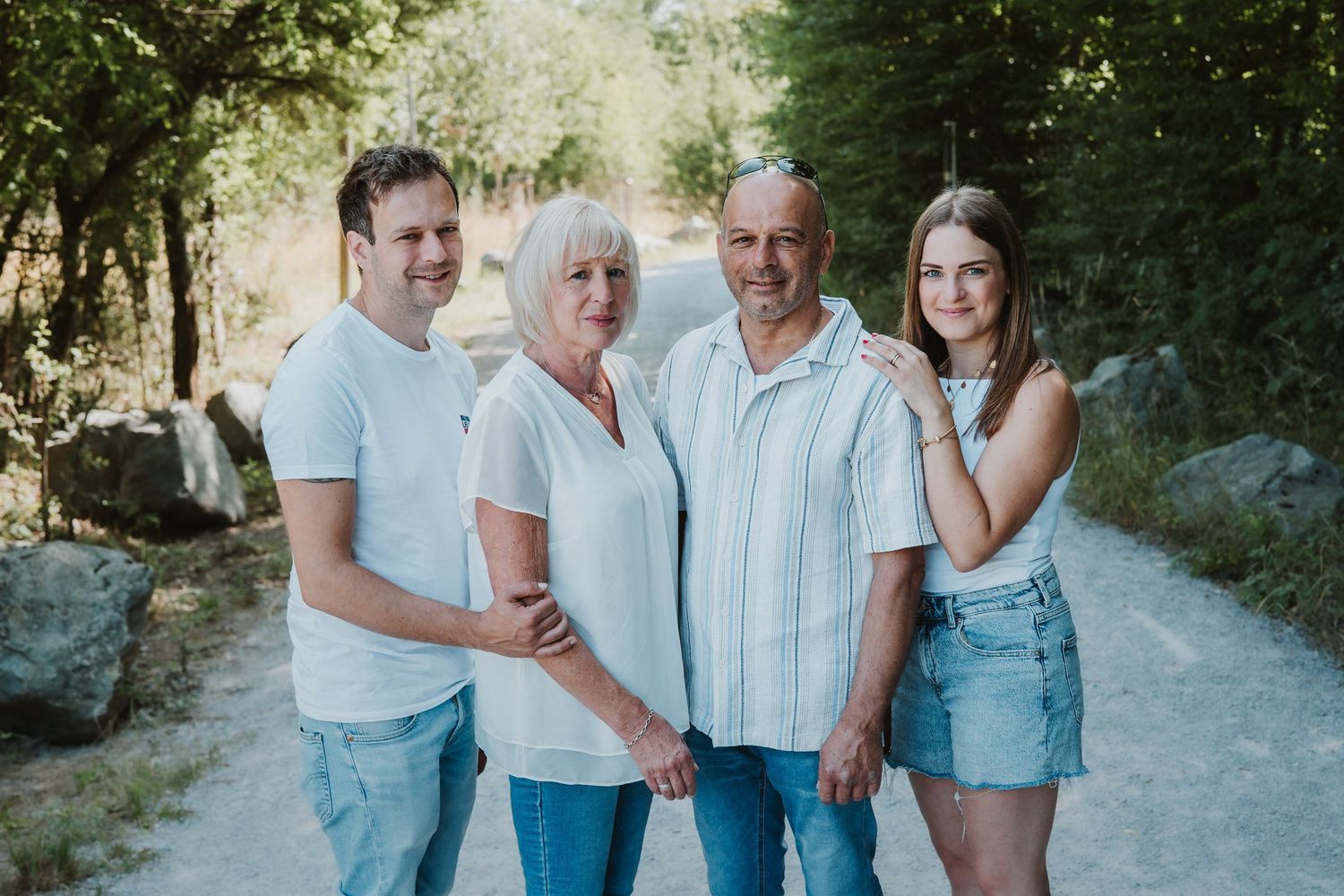 Family group in coordinating blue and white outfits poses together outdoors.
