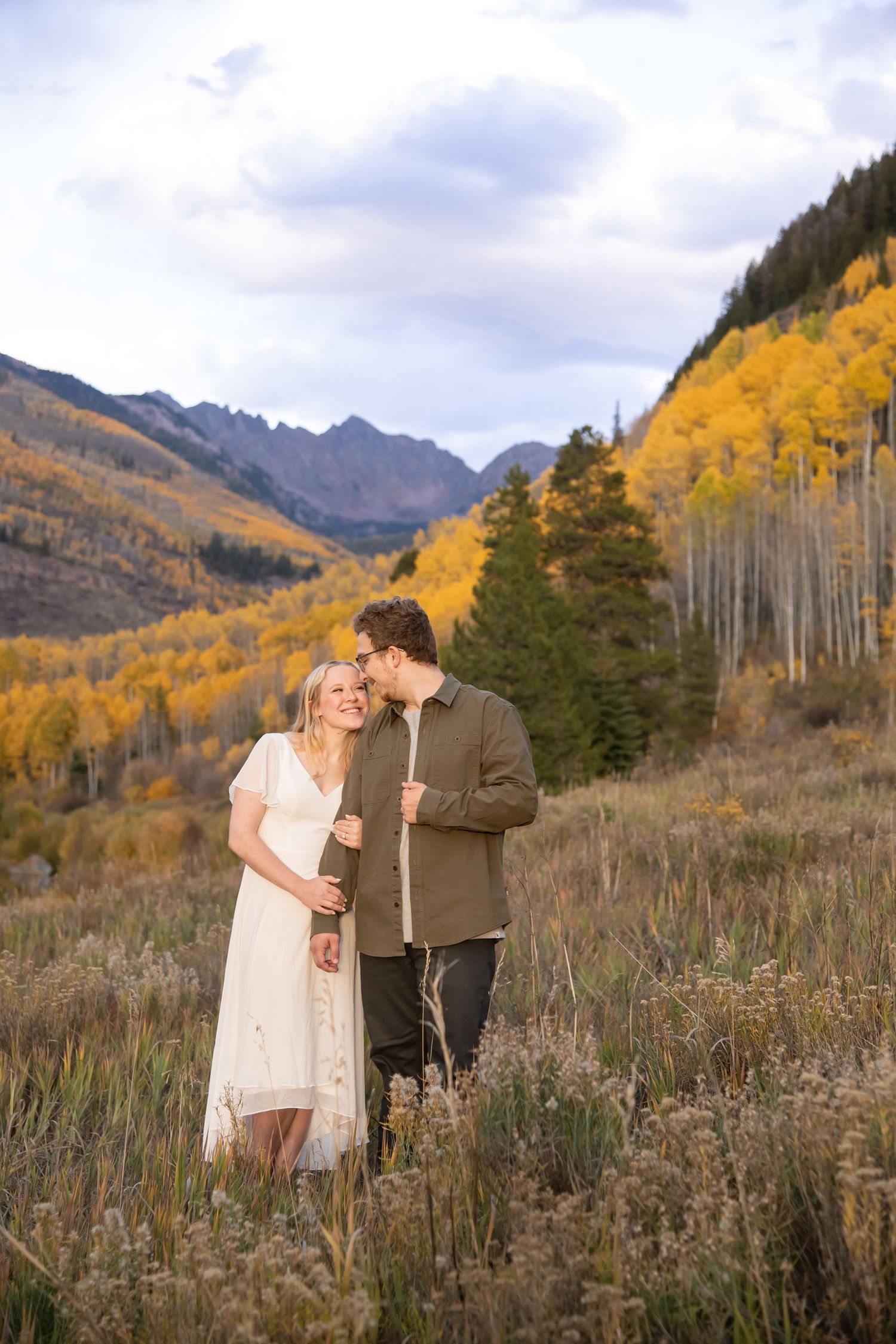 Intimate moment during engagement photos surrounded by golden aspen trees and mountain scenery during autumn in Vail Colorado.