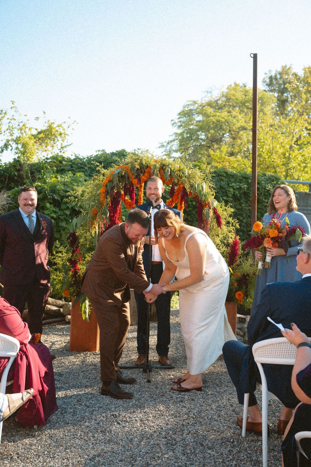 A sequence of outdoor wedding ceremony photos showing the couple and guests under a floral arch at sunset.