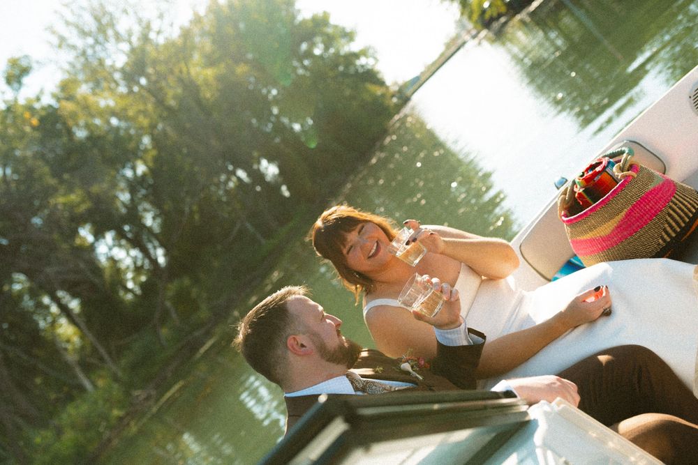 Friends enjoy drinking beer outdoors on a sunny summer day in a park setting.