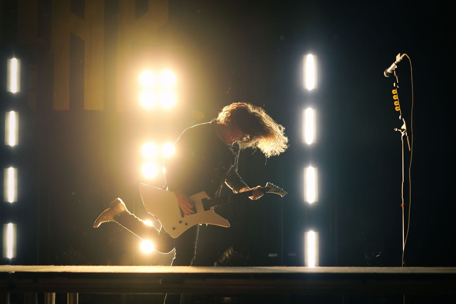 Black and white performance photos showing a dramatic singer on stage in dynamic poses against a dark background.