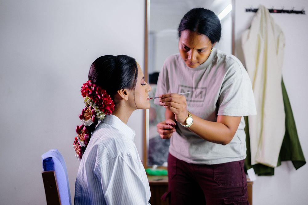 Woman having traditional Indian bridal makeup applied in a series of preparation shots.