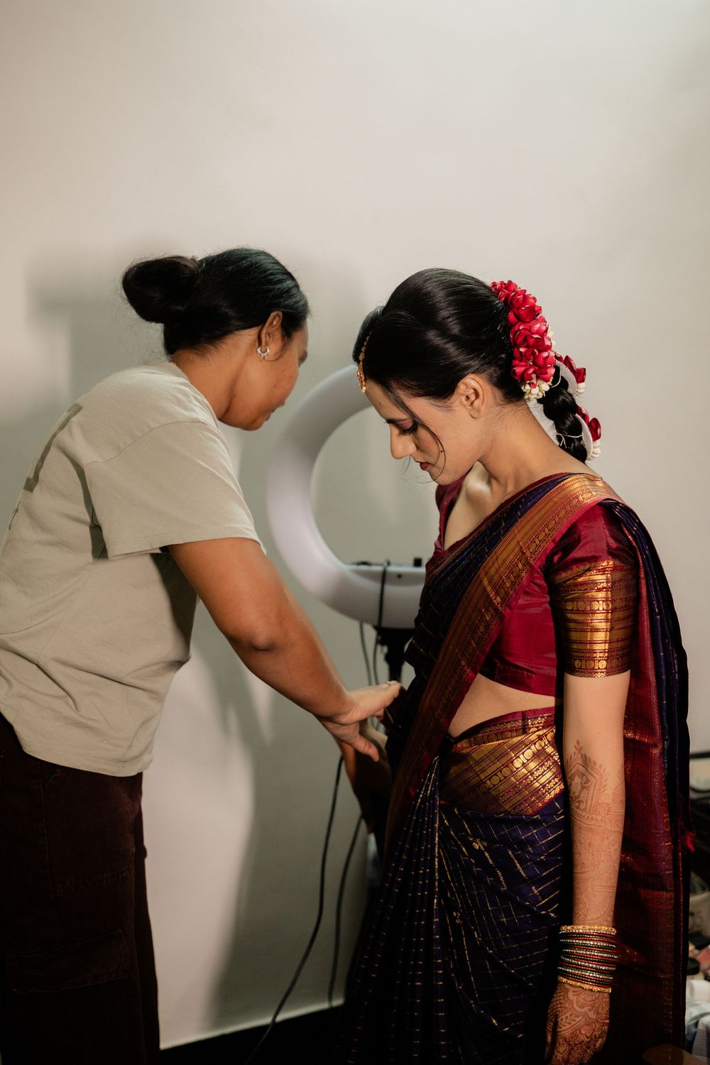 A series of photos showing someone having their bindi applied in a traditional preparation sequence.