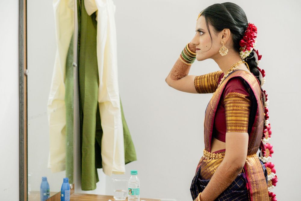 A collection of frames showing someone in traditional Indian attire with red flowers adorning their hair.